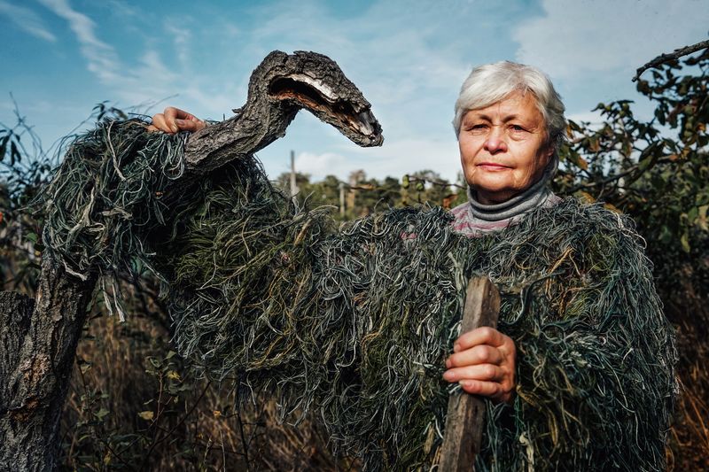 © Alena Grom - Galina in her yard near a tree.