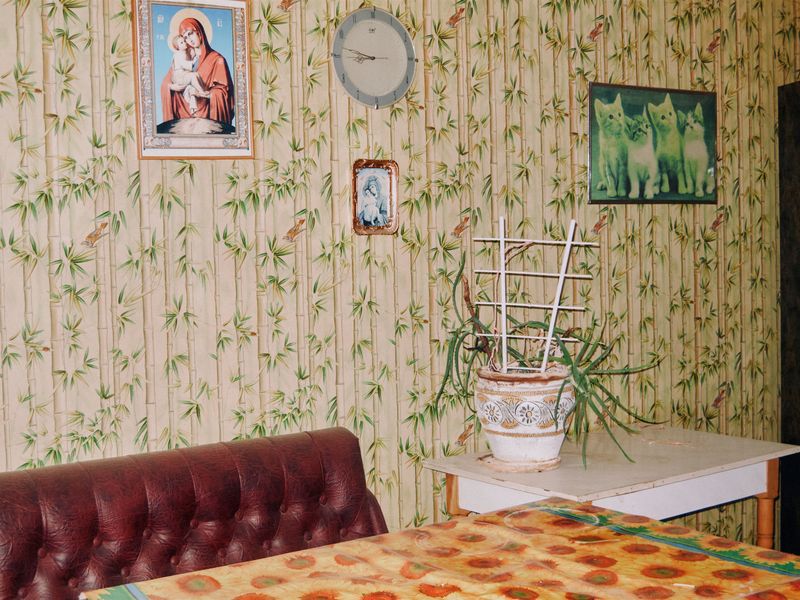 © Anastasia Miseyko - Religious icons, a wall clock, and framed animal images.