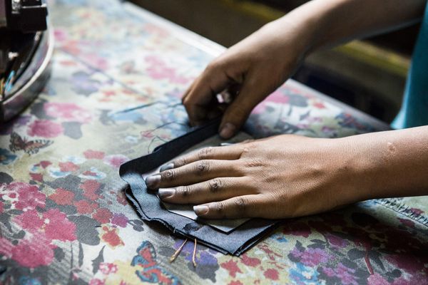 © valeriomuscella - The hands of a Syrian child are seen while ironing a pocket for jeans. Gaziantep, May 2016.