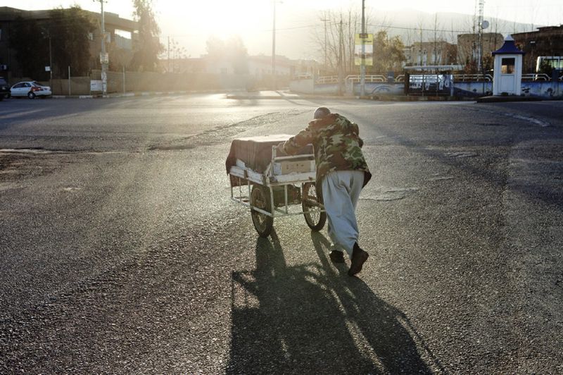 © Antonio Zambardino - Dawn in Halabja. Man with a push-cart shouts to sell kitchen knives in the streets.