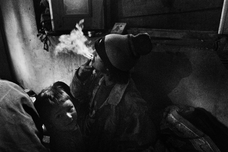 © Harikrishna Katragadda - Hemraj lights up hashish joint next to his son. His wife was arrested and convicted a few years ago for drug trafficking.