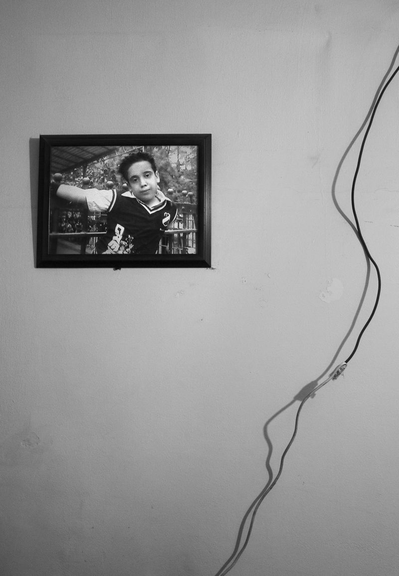 © Lamees Saleh Sharaf Eldin - A picture of Ahmed Jamal , Ten years old, hangs in front of his mother's bed.