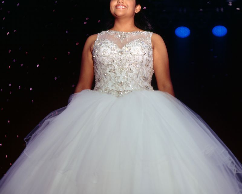 © Samantha Cabrera Friend - Débora Castro smiles for the sea of cameras as she holds her solo pose center stage.