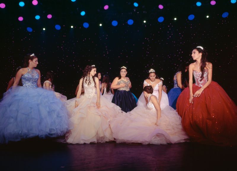 © Samantha Cabrera Friend - A group of quinceañeras in modern dress colors break to help each other get back into final formation.