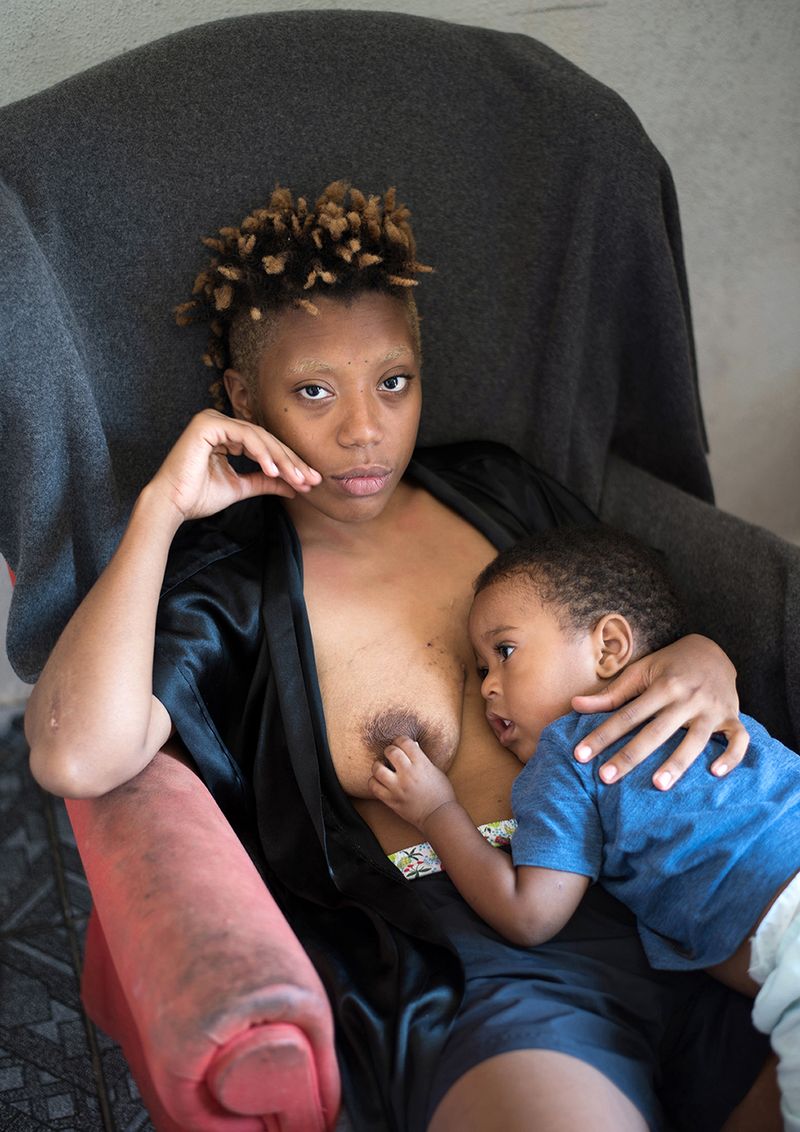 © Camila Falcão - All Ice, rapper, sits in an armchair with his son Malcolm on his lap touching one of his breasts