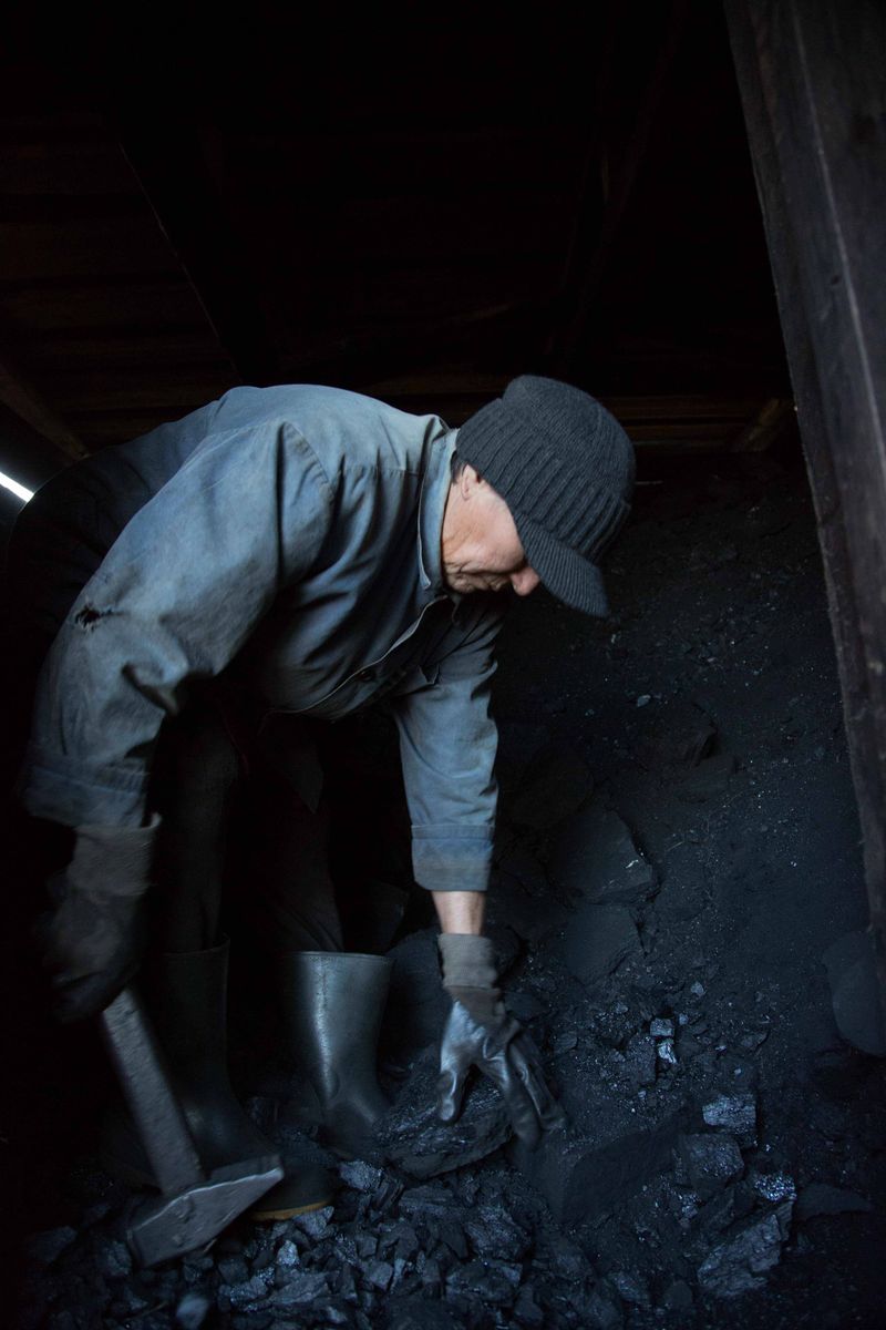 © Sally Low - Valentina ‘cuts’ coal for her indoor stove