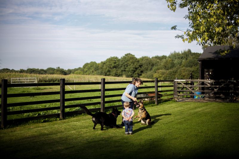 © Sally Low - Crystal with her son Max and the dogs in the garden.