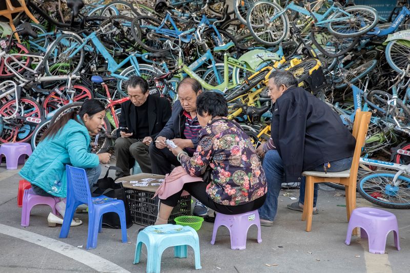 © WU GUOYONG - 18 Shenzhen,China People playing cards in the corner of a community full of shared bicycles. 2018/21/12