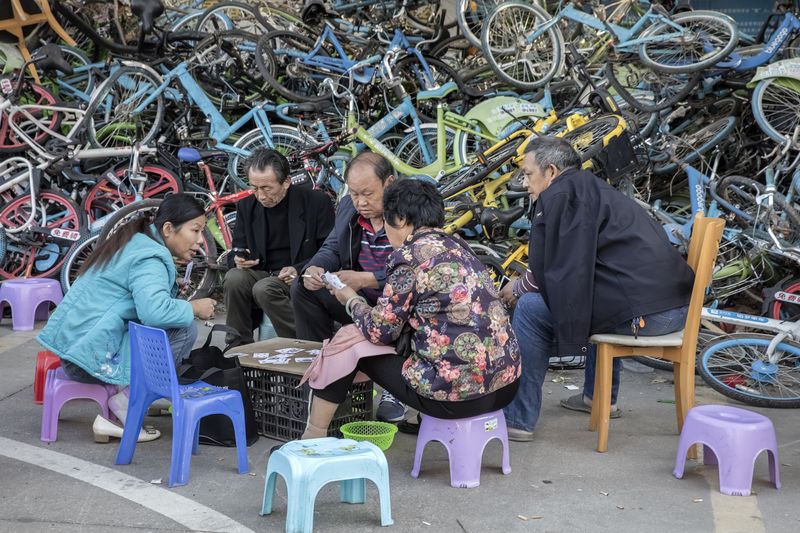 © WU GUOYONG - 18 Shenzhen,China People playing cards in the corner of a community full of shared bicycles. 2018/21/12