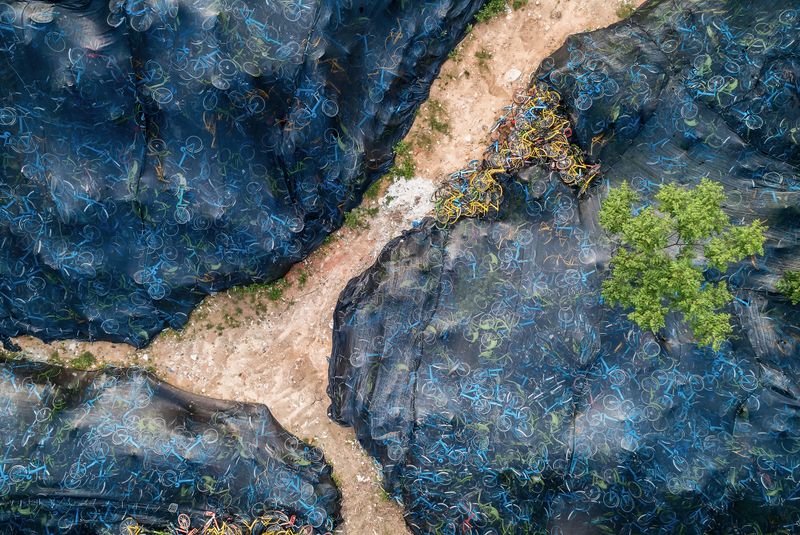 © WU GUOYONG - 12 Guangzhou,China Xiaozhou Art Village, a shared bicycle "graveyield" covered by mesh fabric. 2018/04/17