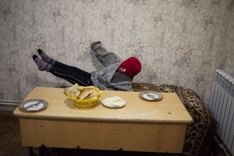© Madelaine Ekserciyan - Armine is a eight year old girl waiting for her old sister to prepare her dinner. In the mean time, she plays.