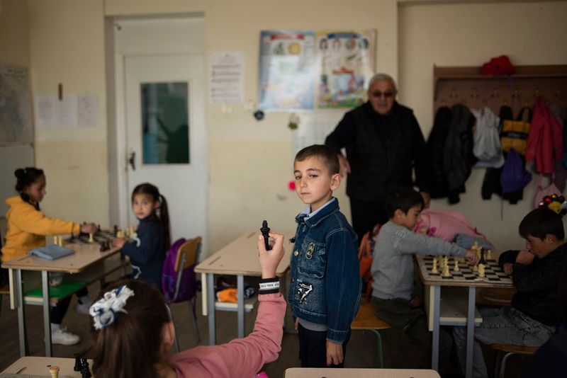 © Madelaine Ekserciyan - Chess class of a second grade in a small town calles Bavra. The girl is showing the boy that she just con the match.