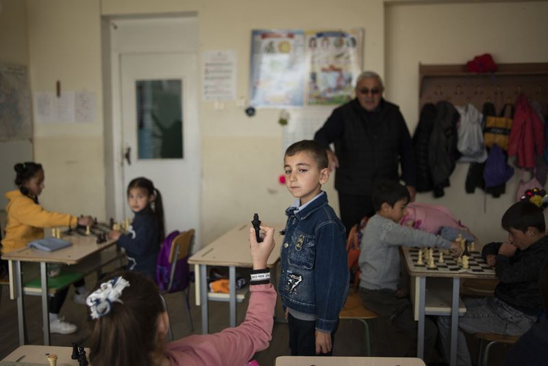 © Madelaine Ekserciyan - Chess class of a second grade in a small town calles Bavra. The girl is showing the boy that she just con the match.