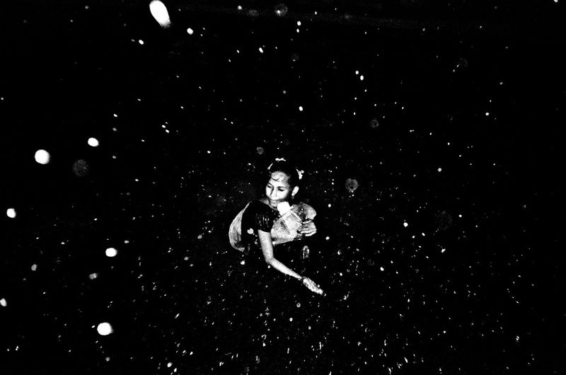 © K. M. Asad - A street girl try to feel rain drop in the street.