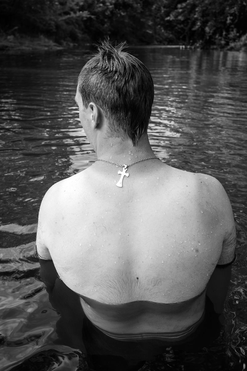 © Caleb Stein - Man’s Back with Crucifix Necklace in Water, The Watering Hole, 2020