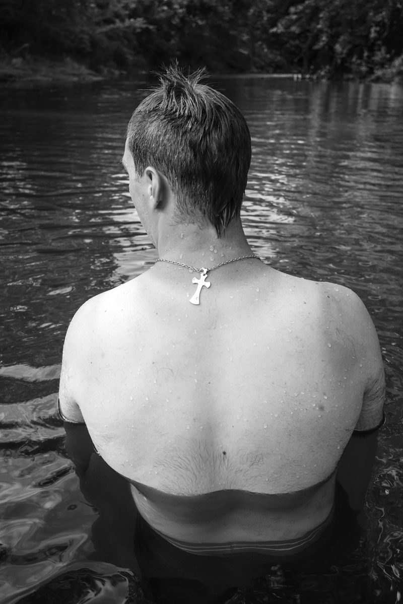 © Caleb Stein - Man’s Back with Crucifix Necklace in Water, The Watering Hole, 2020