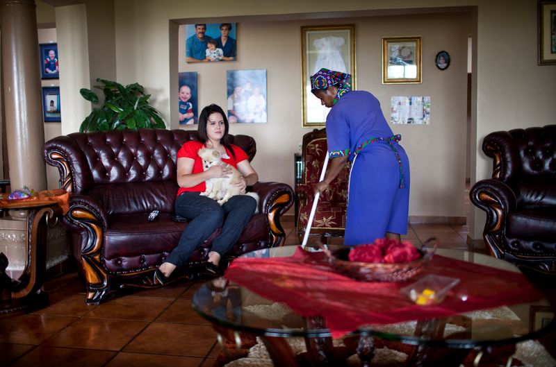 © Ilvy Njiokiktjien - A maid cleanes the house of a family who lives on a farm in Rietfontein, South Africa.