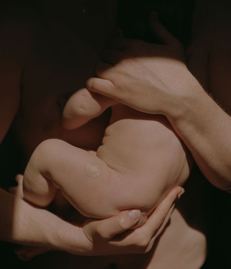 © Tori Ferenc - The Jab. Mila after her 16th-week vaccination, in her dad's arms.