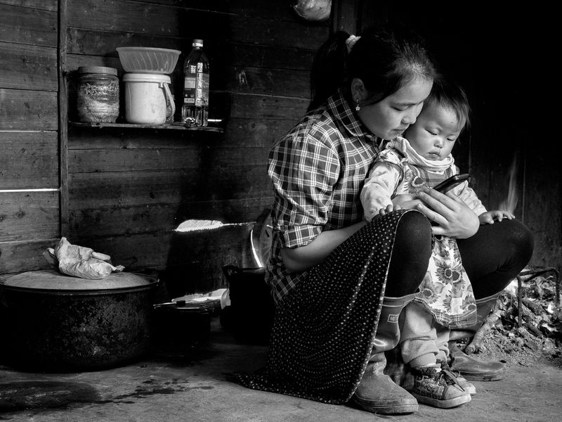 © Tony Corocher - "Ethnic, traditional and modern... the new mix" - Ethnic woman showing her child the new modern ways.