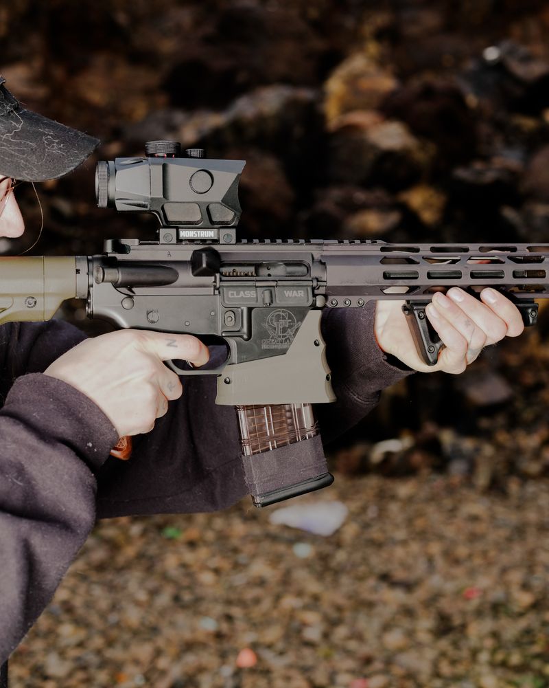 © Jordan Conway - A dust jacket on an AR15 which reads "No War" on one side, and "Class War" on the other.