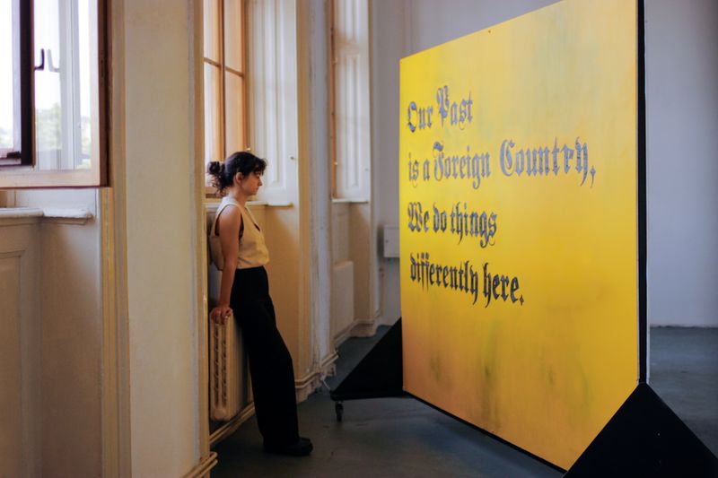 © Caroline Alena Bergwinkl - Our past is a foreign country - Yellow wall (2025). Digital Photograph, site-specific performance at UMPRUM