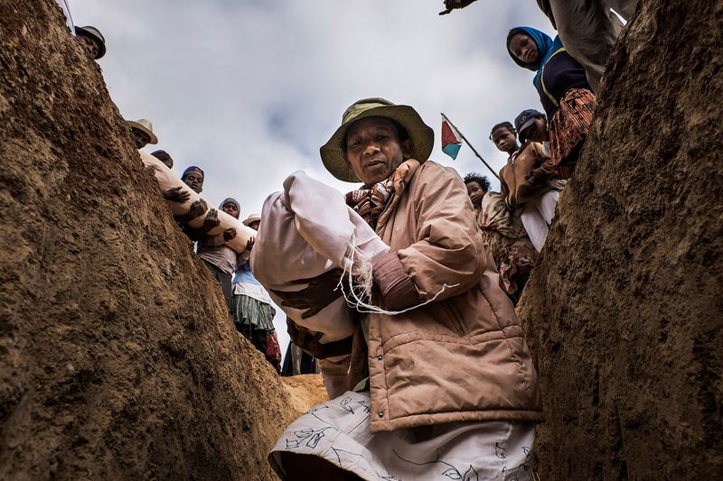 © Klaus Bo - MADAGASCAR - A woman is carrying am ancestor back to the family tomb at the end of the Famadihana.
