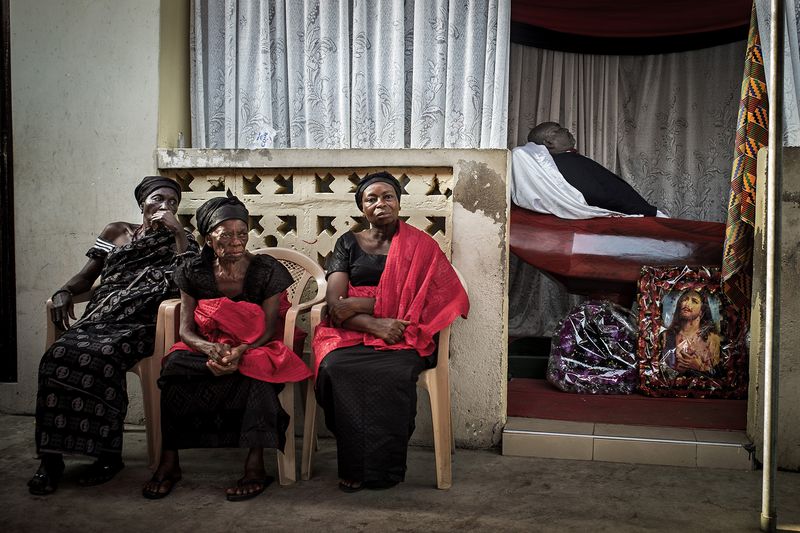 © Klaus Bo - GHANA - Nene Nomo is laying in state while his widow and family members sits outside.
