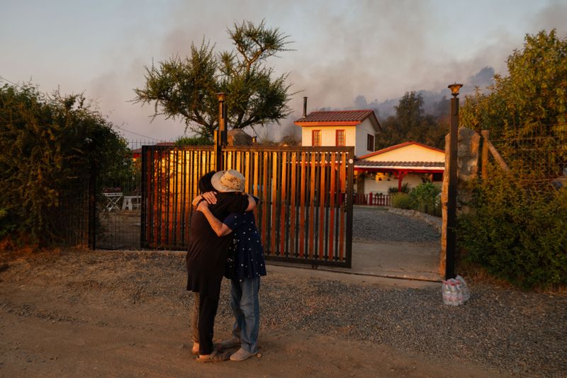 © Stefan Nieland - Blanca (r.) hugs her neighbour as a wildfire approaches her home. Santo Domingo, 17/12/2025.