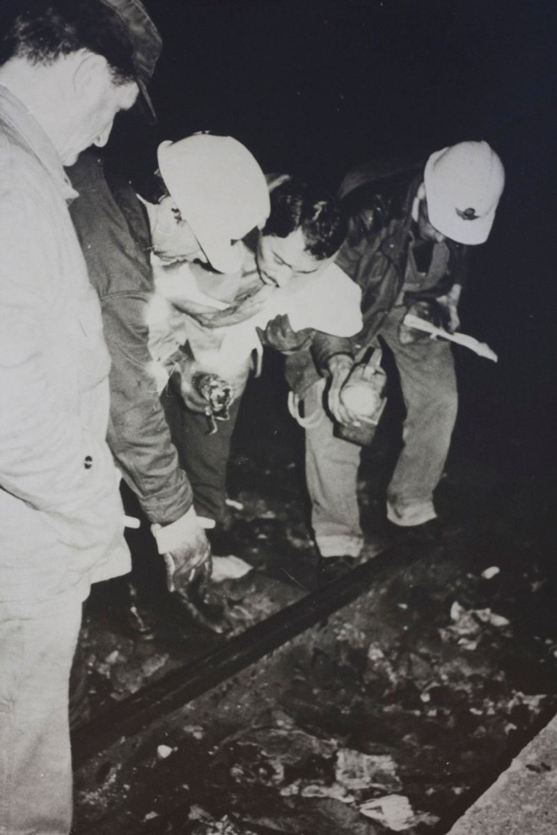 © Martino Lombezzi - FS Italian railway archives. December 23rd, 1984. Railway workers examine the tracks after the explosion took place.