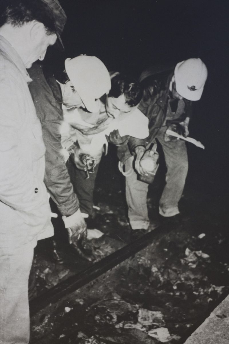 © Martino Lombezzi - FS Italian railway archives. December 23rd, 1984. Railway workers examine the tracks after the explosion took place.