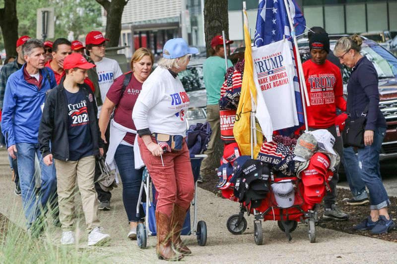 © alexandra buxbaum - Trump merchandise is being sold to people waiting to enter a Trump rally outside of the Toyota Center in Houston, Texas.