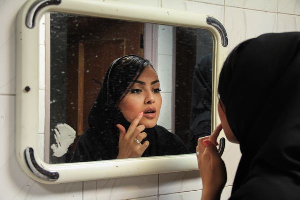 © Mojgan Ghanbari - A female university student is looking at the mirror in the university bathroom. 2013
