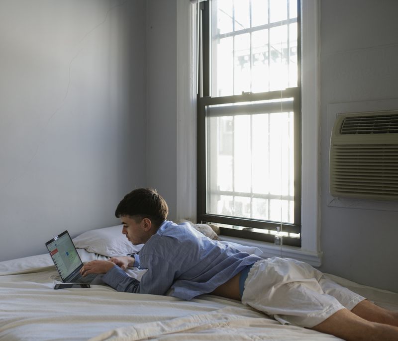 © Gili Benita - Sam (24)m lies on Eyal's bed while answering to whats app messegas on his birthday, April 4th 2020.