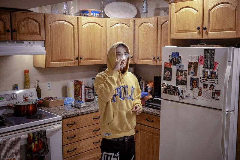 © Jordan Gale - Chris smoking a joint in his childhood kitchen.