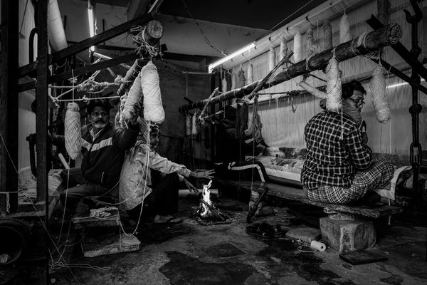 © Simone Campedelli - A small flame burns in the workshop, a fragile warmth that mirrors the rhythm of survival and devotion.