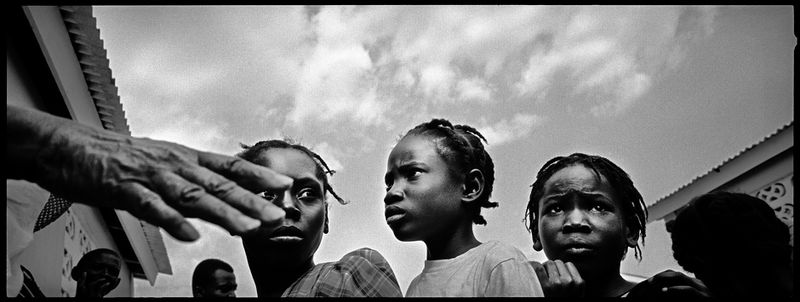 © Benjamin Rusnak - A trio of girls anxiously waits in line for food at a relief agency distribution near Port-au-Prince, Haiti.
