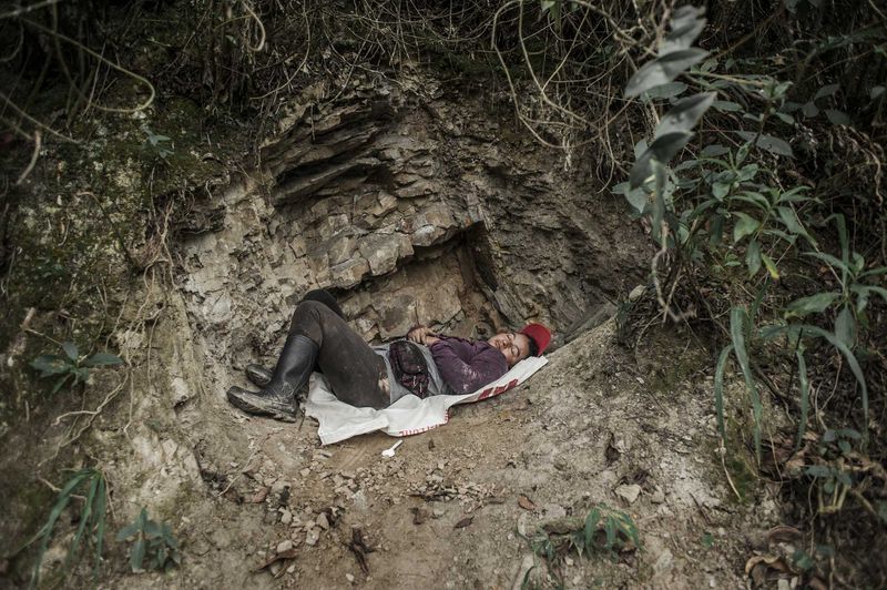© Javier Corso - A female barequera rests after having traveled several miles from her house in search of emeralds.