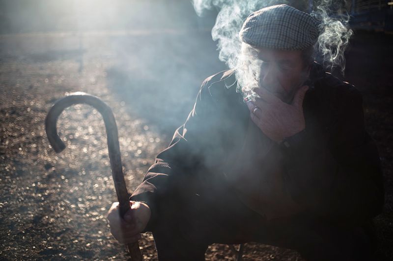 © Susana Giron - Antonio Alarcon, nomad shepherd, smoking a cigarette at early morning during the trashumant migration in Andalucia.
