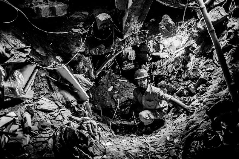 © Rahul Talukder - A rescue worker searching for any sign of life in the last accessible floor of the collapsed building.