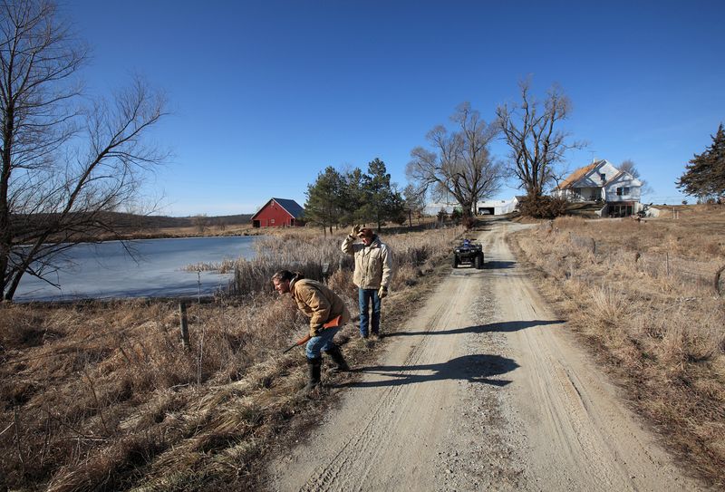 © Tom Atwood - PATRICK STANDLEY & MATT RUSSELL, Farmers Searching for a critter — Lacona, IA