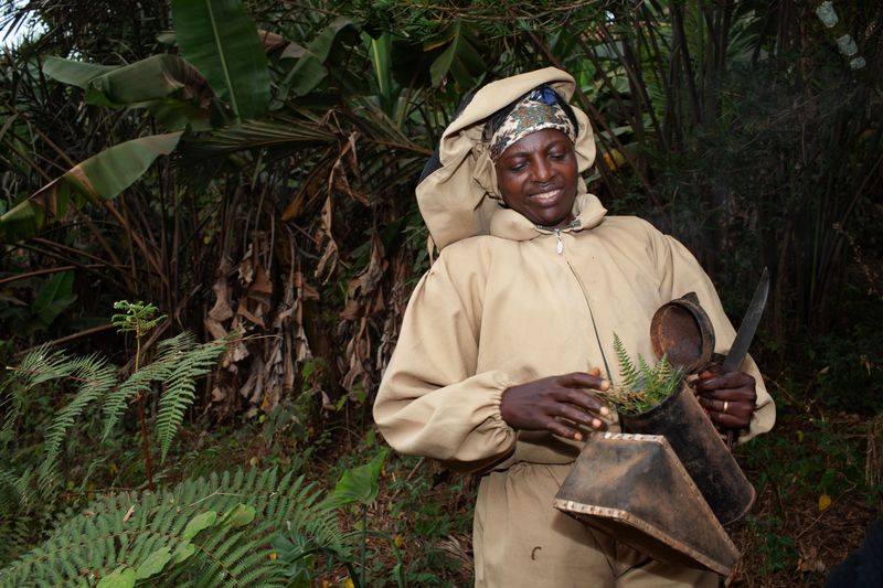 © Eleri Griffiths - Bridget Mbah is secretary of the Bamendankwe bee keeping society. Here, she fuels a smoker, which is used to calm the bees.