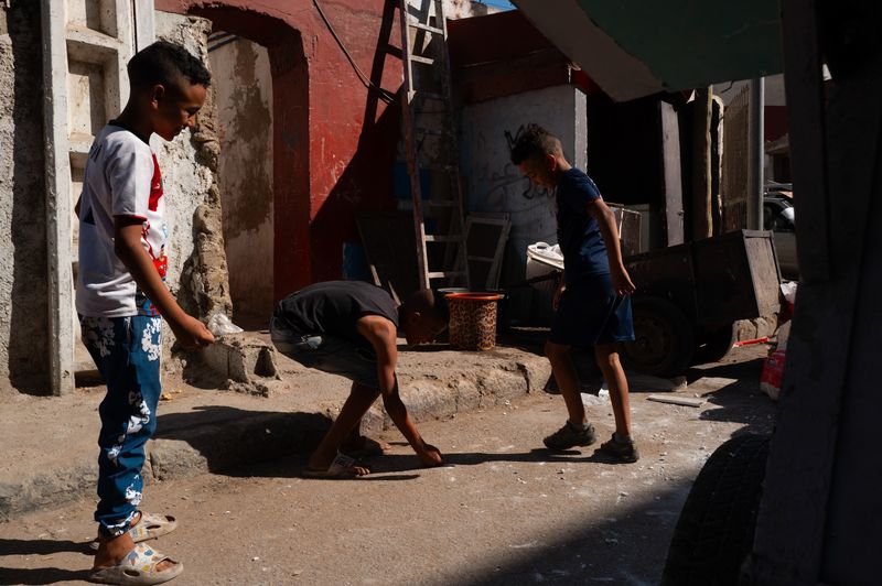 © Jacopo Da Col - Children playing marbles in the chaos of the market.