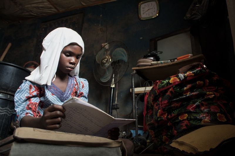 © Igho Ogbobine - Aminat, Halimata’s second child, reading in preparation for the next day’s exam.
