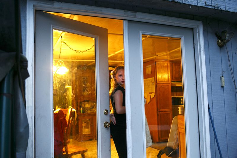 © Maddie Mcgarvey - Sonya peeks out through the door before entering her grandmother's home.