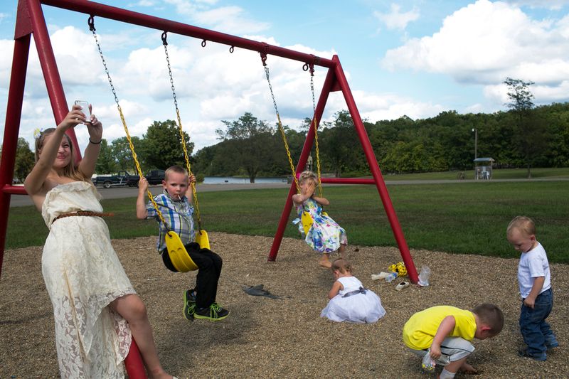 © Maddie Mcgarvey - Sonya, now 13, takes a selfie as her younger siblings and cousins play on the swing set.