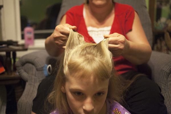 © Maddie Mcgarvey - Lorrie, Sonya's grandmother, braids Sonya's hair before bed. Lorrie is taking care of her daughter Amber's three children.