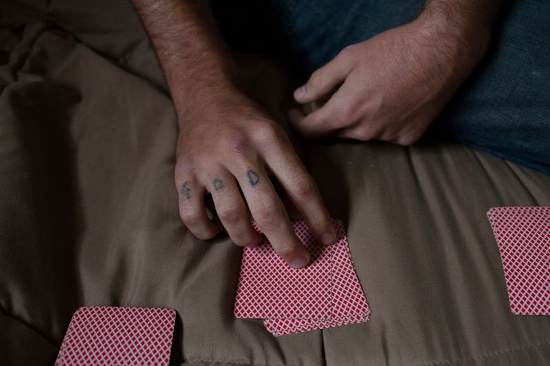 © Sofia Valiente - Doug playing cards inside his room.