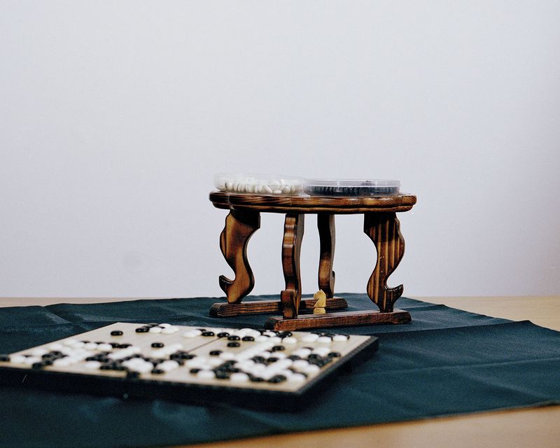 © Juno Joo - A hidden Chess piece surround by Go board and stones.