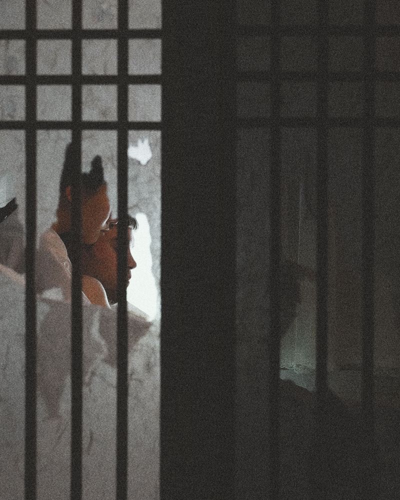© Juno Joo - A couple figures through a hole in window.