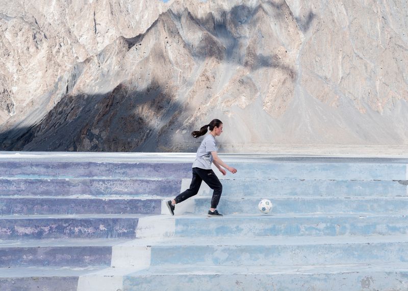 © Giovanni De Mojana - A girl from the football team of Passu is playing by herself.